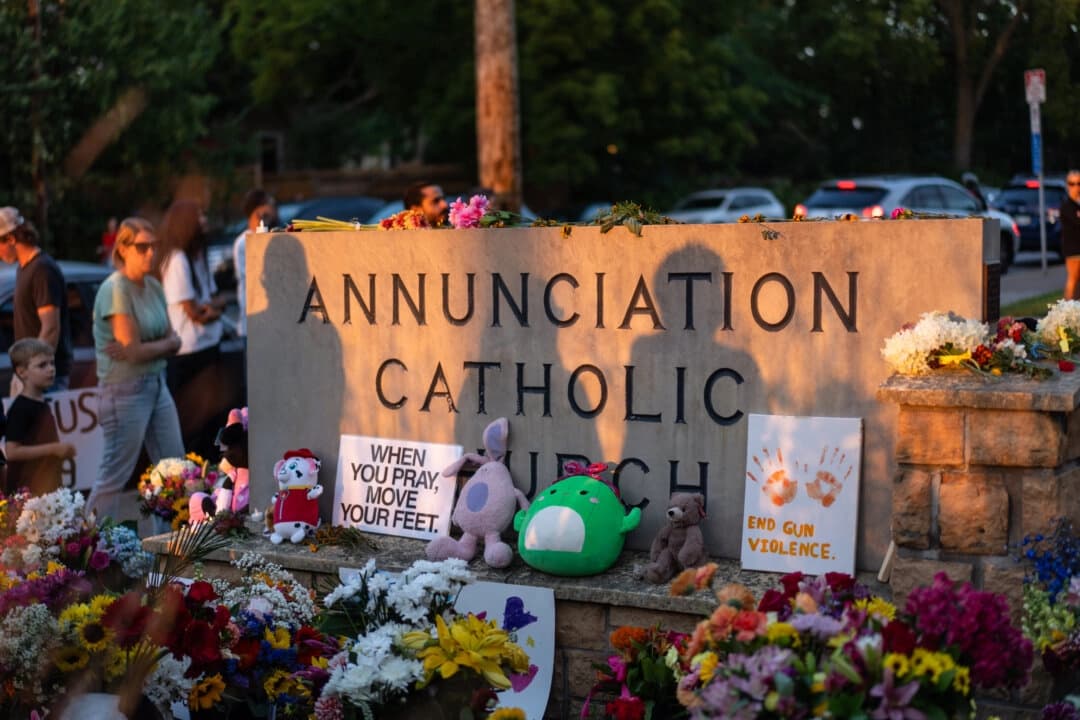 La gente deja flores mientras llora las consecuencias del tiroteo en la Escuela Católica Annunciation en Minneapolis, Minnesota, el 28 de agosto de 2025. (Madalina Kilroy/The Epoch Times)
