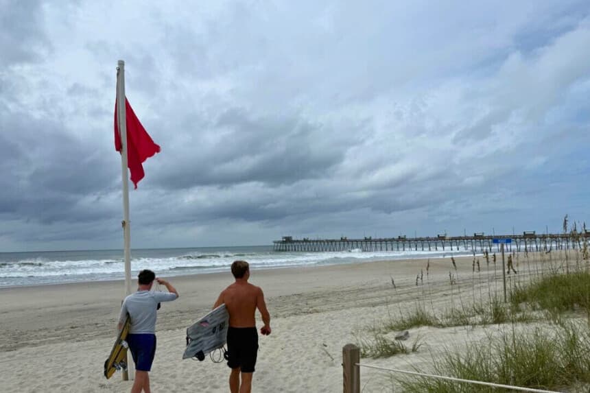 Jack Moore (izquierda) y Owen Mohr se preparan para surfear cerca del muelle pesquero de Bogue Inlet en Emerald Isle, Carolina del Norte, el 20 de agosto de 2025. T.J. Muscaro/The Epoch Times