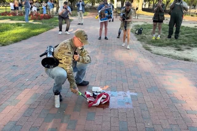 Un hombre quema una bandera estadounidense frente a la Casa Blanca el 25 de agosto de 2025. CNN