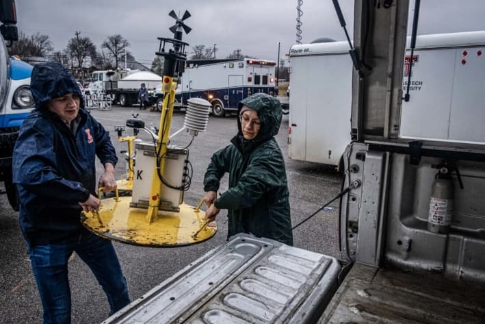 Estudiantes de la Universidad de Illinois llevan una estación meteorológica conocida como StickNet, que recopila datos de temperatura, humedad, presión y viento, durante una jornada educativa de la NOAA para aprender sobre tornados, en Memphis, el 8 de febrero de 2023. (Seth Herald/AFP vía Getty Images)