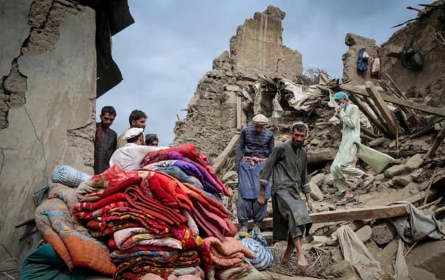 Hombres caminan sobre los escombros de una casa dañada en Mazar Dara, provincia de Kunar, Afganistán, el 2 de septiembre de 2025. (Sayed Hassib/Reuters)