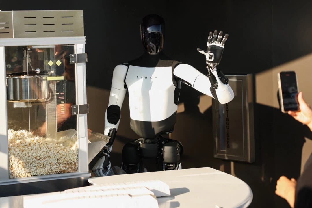 Un robot Tesla Optimus sirve palomitas y saluda a los asistentes al restaurante Tesla Diner and Drive-In y al Supercharger en Los Ángeles el 21 de julio de 2025. (Patrick T. Fallon/AFP/Getty Images)