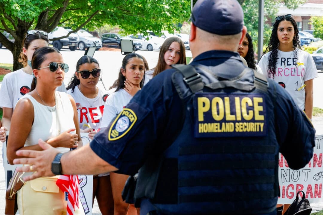Un oficial de Seguridad Nacional habla con compañeros de clase y familiares reunidos frente a la corte de inmigración en Chelmsford, Massachusetts, el 5 de junio de 2025. (Brian Snyder/Reuters).