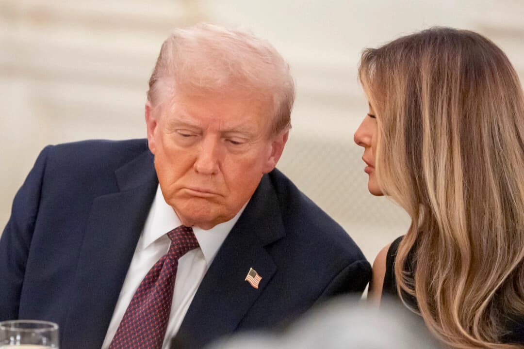 El presidente Donald Trump escucha mientras la primera dama Melania Trump le repite una pregunta durante una cena en el comedor de estado de la Casa Blanca, el jueves 4 de septiembre de 2025, en Washington. (AP Photo/Alex Brandon).