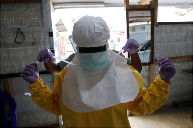 Un trabajador de la salud se pone el equipo de protección contra el ébola antes de ingresar a la Unidad de Atención de Emergencia Biosegura en el centro de tratamiento del ébola de la Alianza para la Acción Médica Internacional en Beni, en la República Democrática del Congo, el 31 de marzo de 2019. REUTERS/Baz Ratner/Foto de archivo