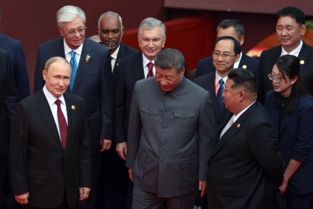 El presidente ruso, Vladimir Putin (izq.), habla con el líder chino, Xi Jinping (centro), y el norcoreano, Kim Jong Un (der.), tras una fotografía grupal antes de un desfile militar para conmemorar el 80.º aniversario del fin de la Segunda Guerra Mundial, en la Plaza de Tiananmén en Pekín el 3 de septiembre de 2025. (Alexander Kazakov/Pool/AFP vía Getty Images)