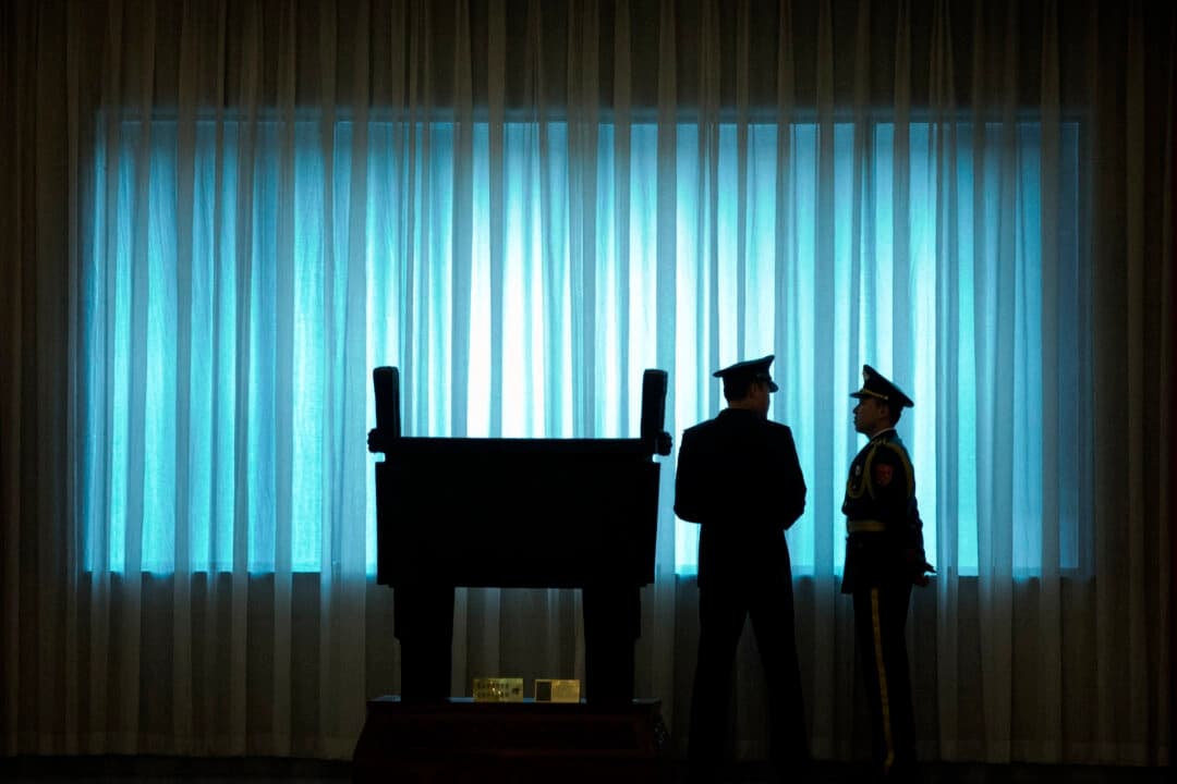 Oficiales del Ejército Popular de Liberación de China (EPL) posan frente a una ventana antes de la ceremonia de bienvenida al jefe del Estado Mayor del Ejército de Estados Unidos, el general Mark Milley, en el edificio Bayi de Beijing, el 16 de agosto de 2016. (Mark Schiefelbein/POOL/AFP a través de Getty Images)
