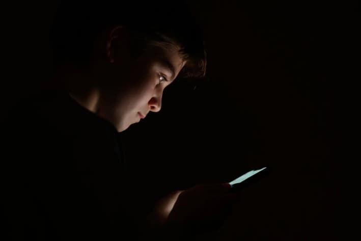 Un adolescente mira la pantalla de un teléfono móvil, en Londres, el 17 de enero de 2023. (Leon Neal/Getty Images)