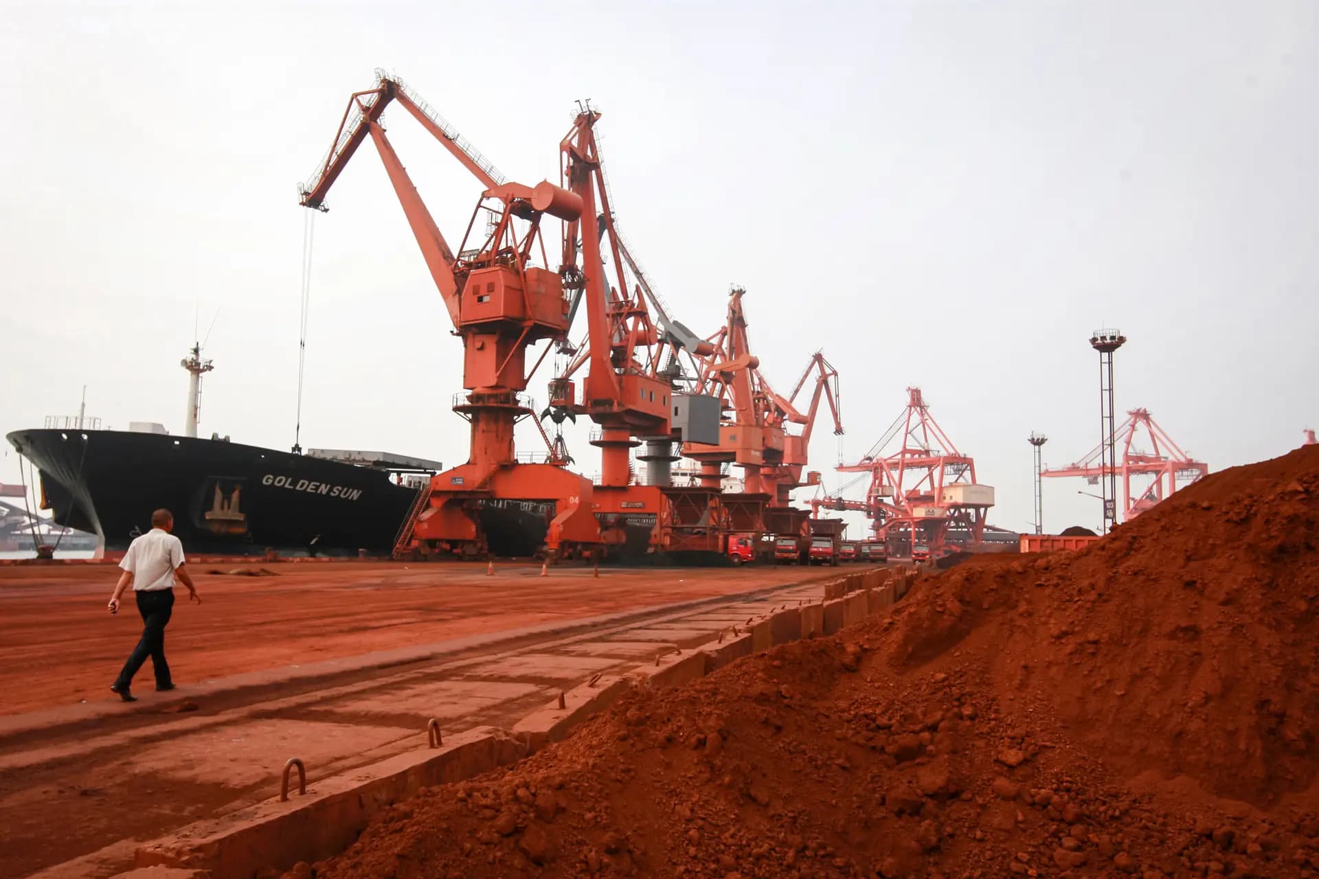 El 5 de septiembre de 2010, en un puerto de Lianyungang, provincia de Jiangsu, China, unas excavadoras recogen tierra que contiene minerales de tierras raras para cargarla en un barco y exportarla. China tiene casi el monopolio de la industria de las tierras raras. (STR/AFP a través de Getty Images).