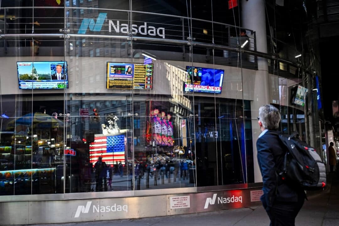 Una persona mira las pantallas de televisión que muestran noticias económicas en el NASDAQ MarketSite de Times Square, Nueva York, el 9 de abril de 2025. (Angela Weiss/AFP)
