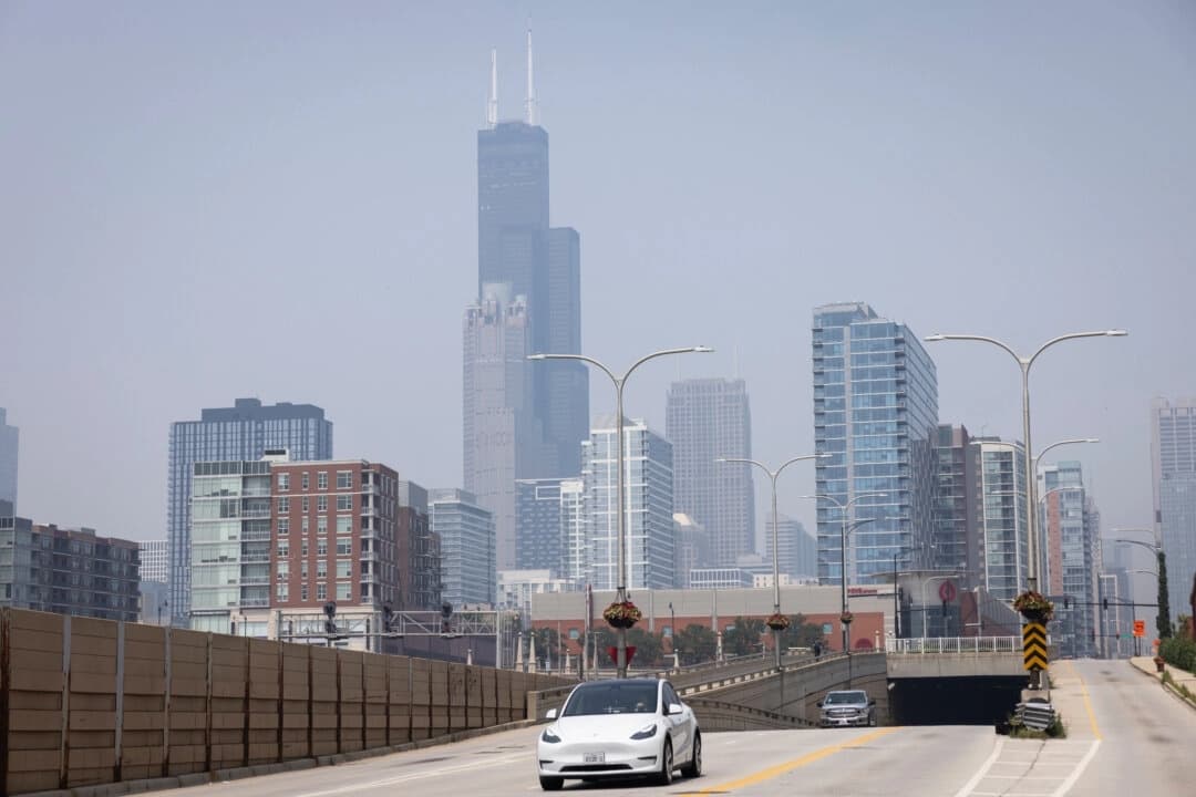 La gente conduce por South Clark Street, cerca de West 15th Street, en el lado sur, mientras una nube de humo procedente de los incendios forestales de Canadá cubre el área de Chicago, el 31 de julio de 2025. (Ashlee Rezin/Chicago Sun-Times vía AP)

