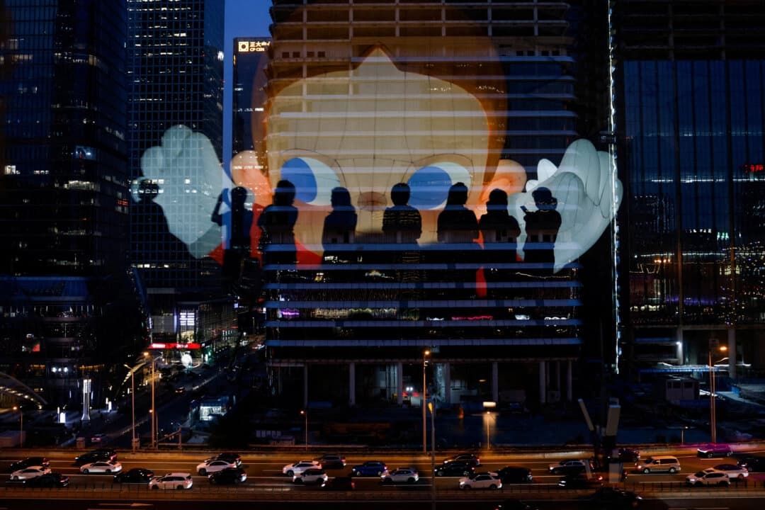 El reflejo de las siluetas de las personas se ve en un cristal de la terraza de un centro comercial con vistas al distrito comercial central de Beijing, el 11 de agosto de 2025. (Tingshu Wang/Reuters)
