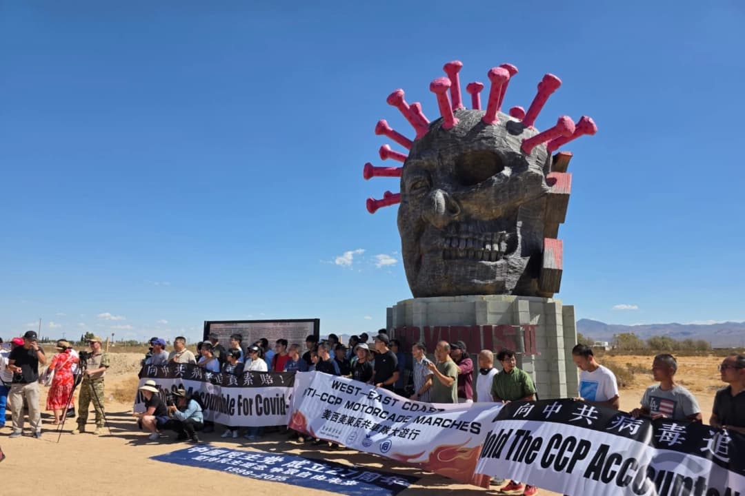 Los participantes en la carrera automovilística a través del país posan delante de la estatua del virus del PCCh en el Liberty Sculpture Park, en la localidad de Yermo, en el desierto de Mojave, California, el 6 de septiembre de 2025. (Cortesía de Chen Weiming)