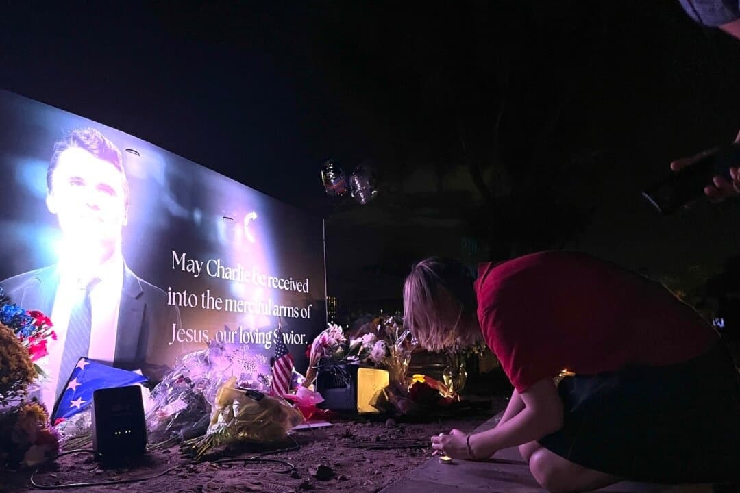 Katy, que vive en Phoenix y asiste a una escuela secundaria católica privada, enciende una vela al pie de un altar en honor al activista conservador asesinado Charlie Kirk en Phoenix, el 10 de septiembre de 2025. (Allan Stein/The Epoch Times)
