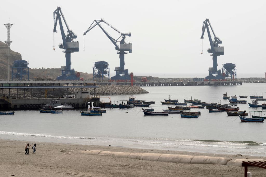 Grúas del megapuerto de Chancay se ven desde el puerto de la ciudad, donde descansan embarcaciones pesqueras tradicionales, a 78 kilómetros al norte de Lima, la capital peruana, el 29 de octubre de 2024. Estaba prevista su inauguración el 14 de noviembre de 2024 por la presidente de Perú Dina Boluarte y el líder chino Xi Jinping, en el marco de la cumbre de Cooperación Económica Asia-Pacífico (APEC) en Lima. (Foto de CRIS BOURONCLE/AFP vía Getty Images)