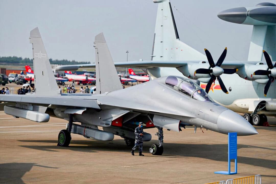 Un oficial militar pasa junto al caza de ataque multifunción J-16 de Shenyang Aircraft Corporation, perteneciente a la Fuerza Aérea del Ejército Popular de Liberación (PLAAF), en la 13.ª Exposición Internacional de Aviación y Aeroespacial de China, celebrada en Zhuhai, provincia de Guangdong, en el sur de China, el 28 de septiembre de 2021. (Noel Celis/AFP vía Getty Images)

