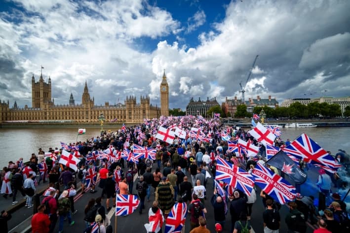 Manifestantes ondean banderas durante la manifestación "Unite The Kingdom" (Unir el Reino) en el puente de Westminster, junto a las Cámaras del Parlamento, en Londres, el 13 de septiembre de 2025. (Christopher Furlong/Getty Images)