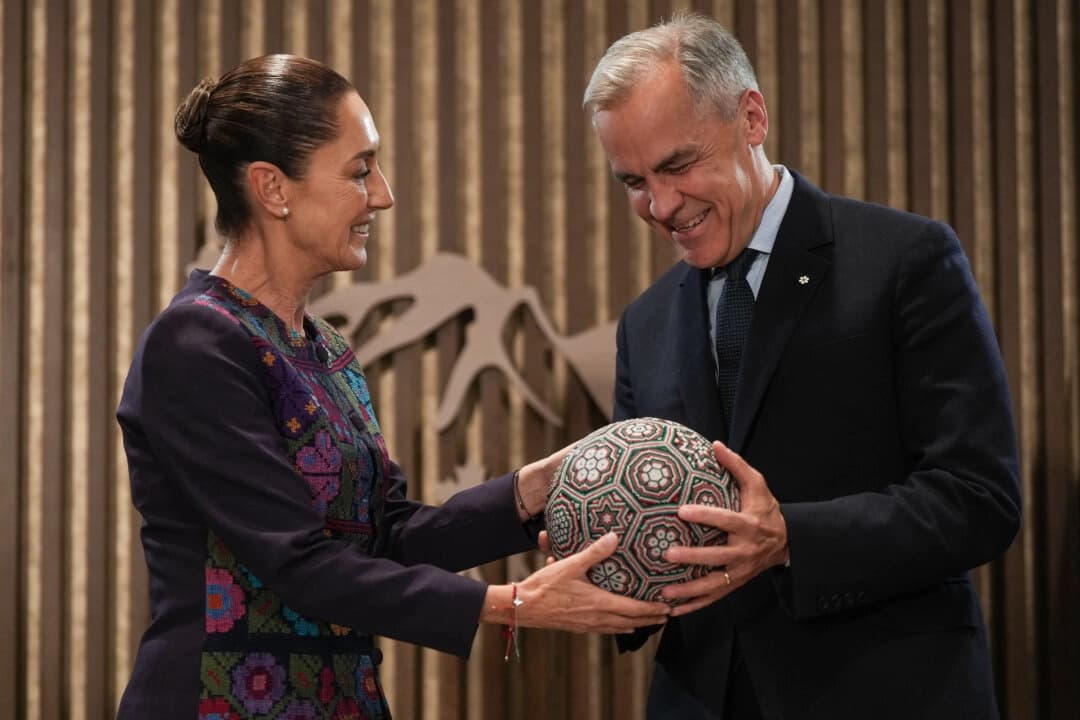 La presidenta mexicana Claudia Sheinbaum, a la izquierda, entrega al primer ministro canadiense Mark Carney un balón de fútbol con motivos artísticos huicholes bordados con abalorios antes de una reunión en la cumbre del G7 en Kananaskis, Alberta, el 17 de junio de 2025. (Darryl Dyck/The Canadian Press)