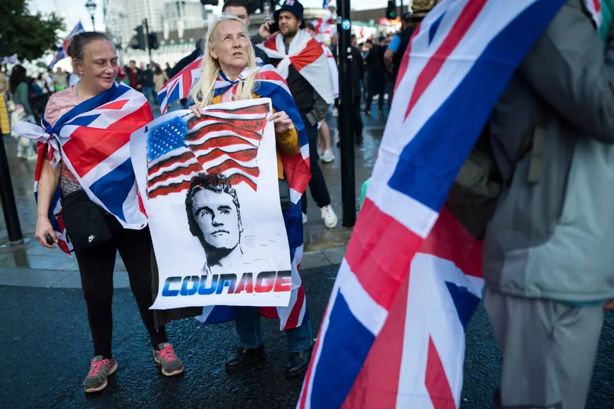 Manifestantes llevan un cartel con la imagen del difunto Charlie Kirk durante la concentración "Unite The Kingdom" en el puente de Westminster, junto al Parlamento de Londres, el 13 de septiembre de 2025. (Christopher Furlong/Getty Images)