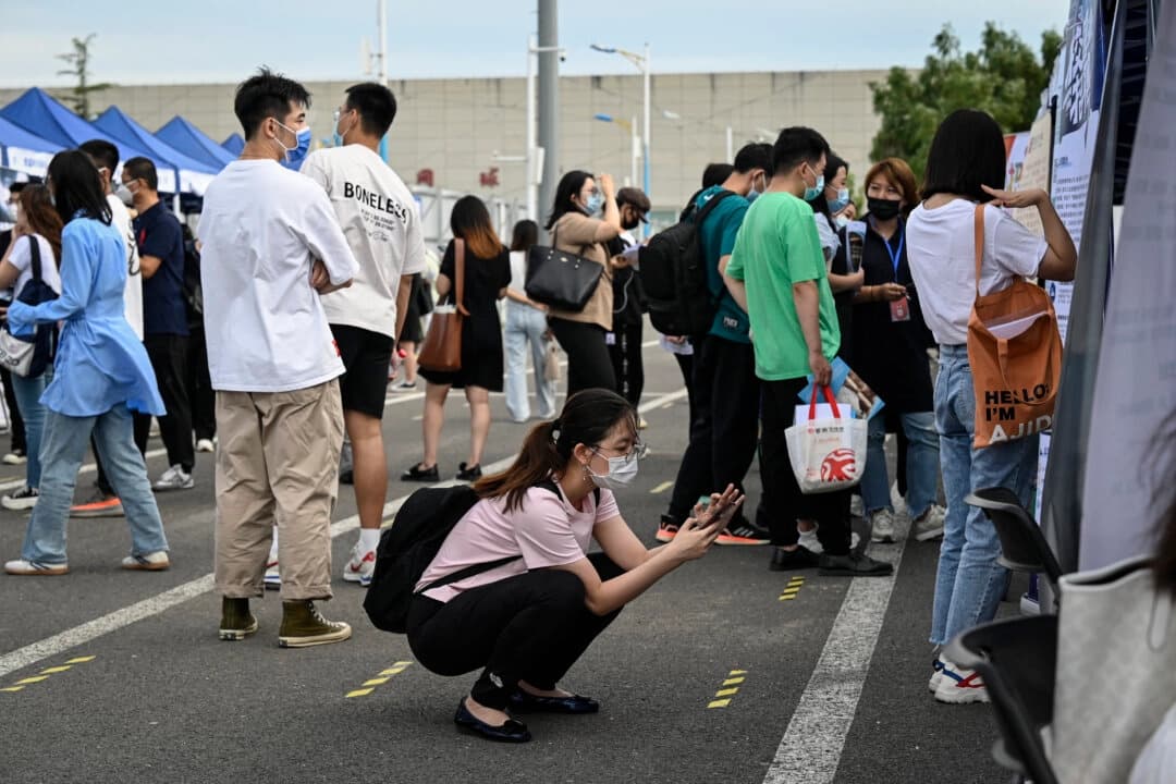 Una mujer utiliza su teléfono durante una feria de empleo en Pekín, China, el 26 de agosto de 2022. (Jade Gao/AFP a través de Getty Images)
