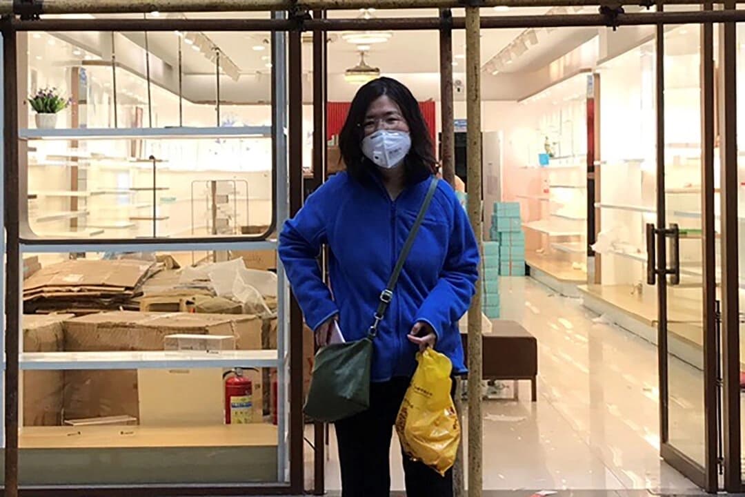 Zhang Zhan junto a un andamio frente a una tienda durante una visita a Wuhan, en la provincia de Hubei (China), el 11 de abril de 2020. (Cortesía de Melanie Wang a través de AP)
