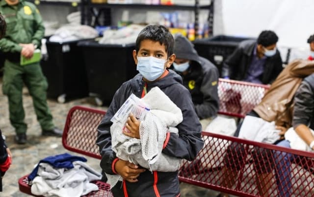 Un joven inmigrante ilegal espera para ducharse en el principal centro de detención del Departamento de Seguridad Nacional para niños inmigrantes ilegales no acompañados, en el Valle del Río Grande, en Donna, Texas, el 30 de marzo de 2021. (Dario Lopez-Mills/AFP vía Getty Images)