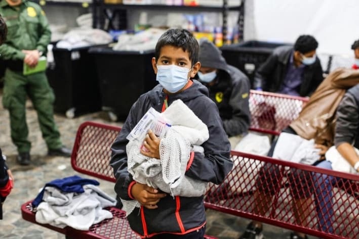 Un joven inmigrante ilegal espera para ducharse en el principal centro de detención del Departamento de Seguridad Nacional para niños inmigrantes ilegales no acompañados, en el Valle del Río Grande, en Donna, Texas, el 30 de marzo de 2021. (Dario Lopez-Mills/AFP vía Getty Images)