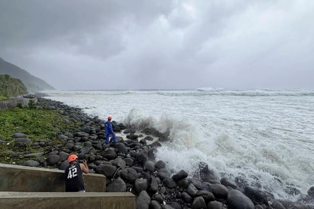 La gente observa cómo las fuertes olas azotan Basco, en la provincia de Batanes, al norte de Filipinas, mientras el tifón Ragasa afecta la zona el 22 de septiembre de 2025. (Justine Mark Pillie Fajardo/AP Photo)
