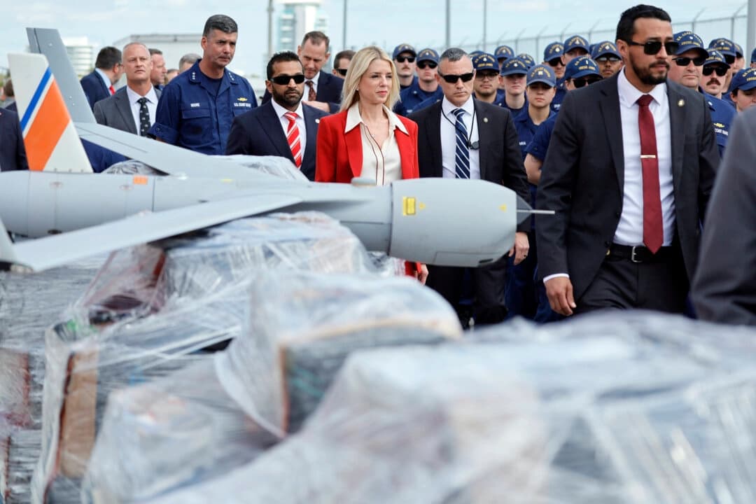 La fiscal general Pam Bondi y el director del FBI, Kash Patel, pasan junto a palés de narcóticos envueltos en plástico y un dron utilizado en las investigaciones a su llegada a una conferencia de prensa en Port Everglades, Florida, el 9 de abril de 2025. (Amy Beth Bennett/South Florida Sun-Sentinel vía AP)
