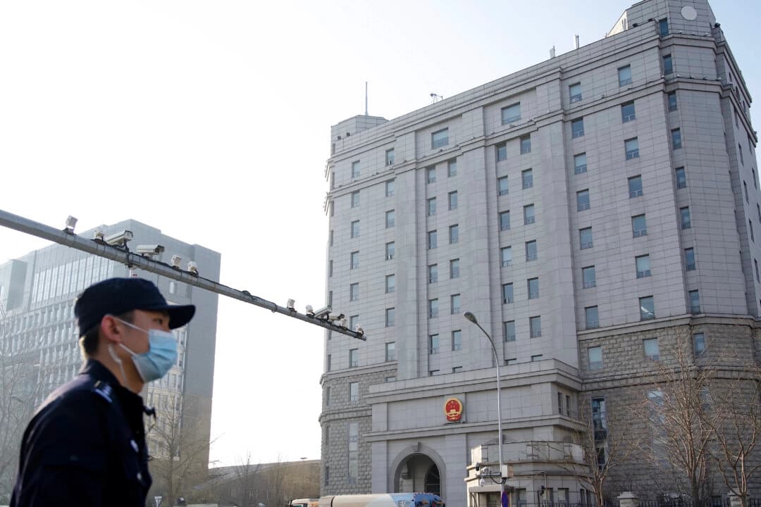 Un policía junto a una fila de cámaras de vigilancia frente al Tribunal Popular Intermedio n.º 2 de Beijing, en Beijing, el 31 de marzo de 2022. (Noel Celis/AFP a través de Getty Images).
