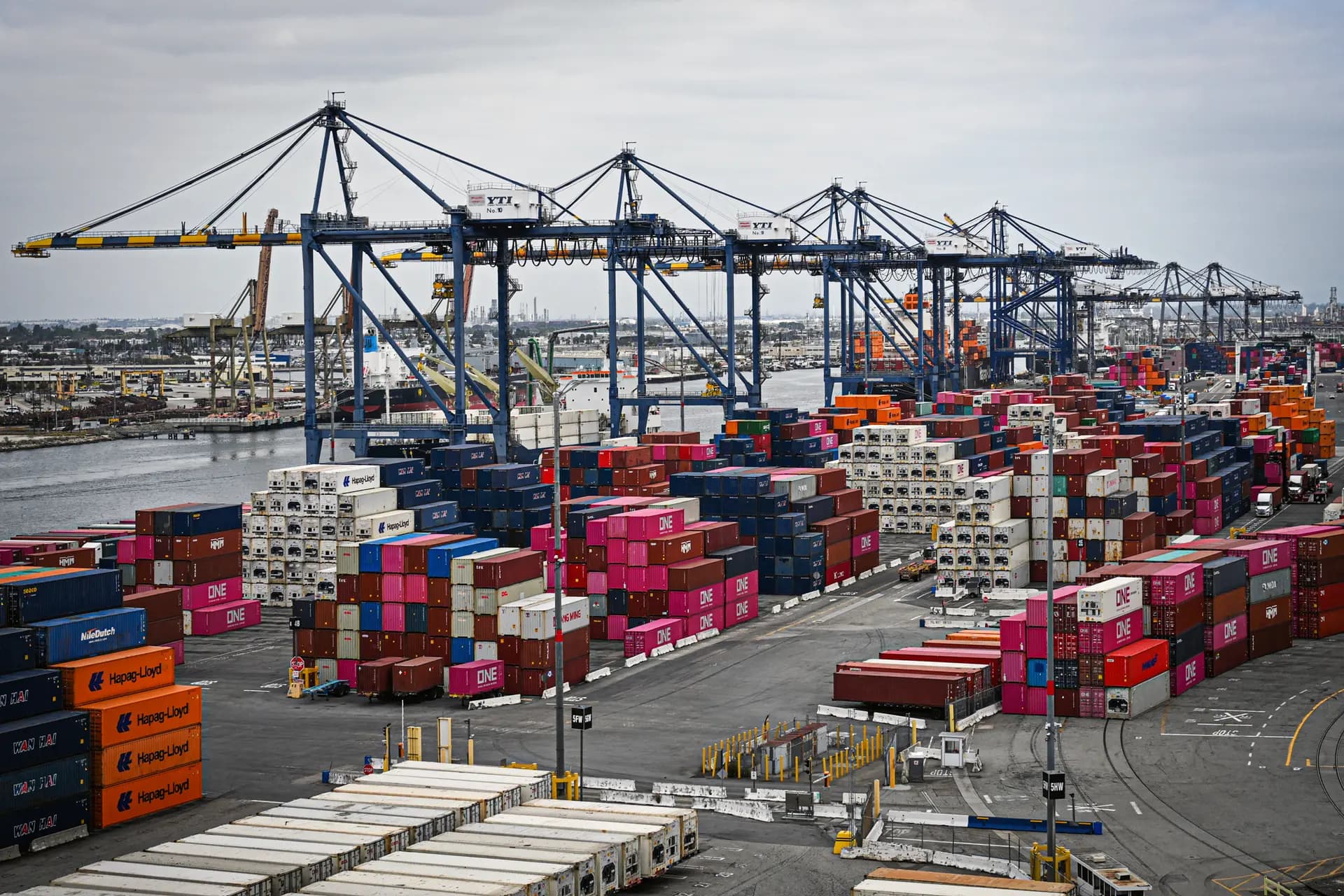 Los contenedores de transporte se apilan mientras las grúas descargan los buques mercantes en el puerto de Los Ángeles, en San Pedro, California, el 15 de abril de 2025. (Patrick T. Fallon/AFP a través de Getty Images).