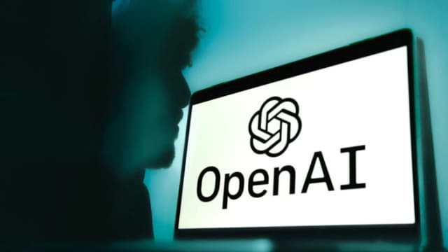 Un portátil con el logotipo de Open AI sobre un fondo azul degradado con la sombra de un hombre al fondo en Grenoble, Francia, el 12 de febrero de 2025. Anouk Anglade/Hans Lucas/AFP a través de Getty Images
