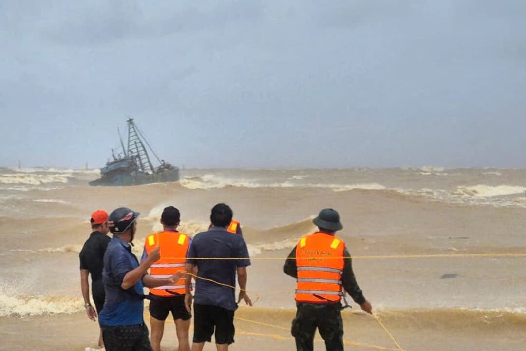 La gente trabaja para rescatar a los pescadores de un barco varado debido al tifón Bualoi en Quang Tri, Vietnam, el domingo 28 de septiembre de 2025. (Trinh Quoc Dung/VNA vía AP)