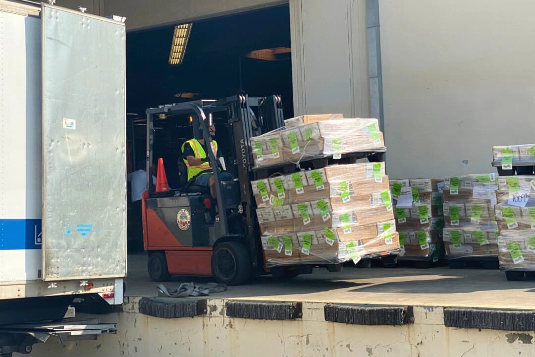 Una carretilla elevadora se prepara para cargar papeletas electorales por correo en un camión en un muelle de carga fuera de la oficina del Registro del Condado de Orange en Santa Ana, California, el 5 de octubre de 2020. (Jamie Joseph/The Epoch Times)