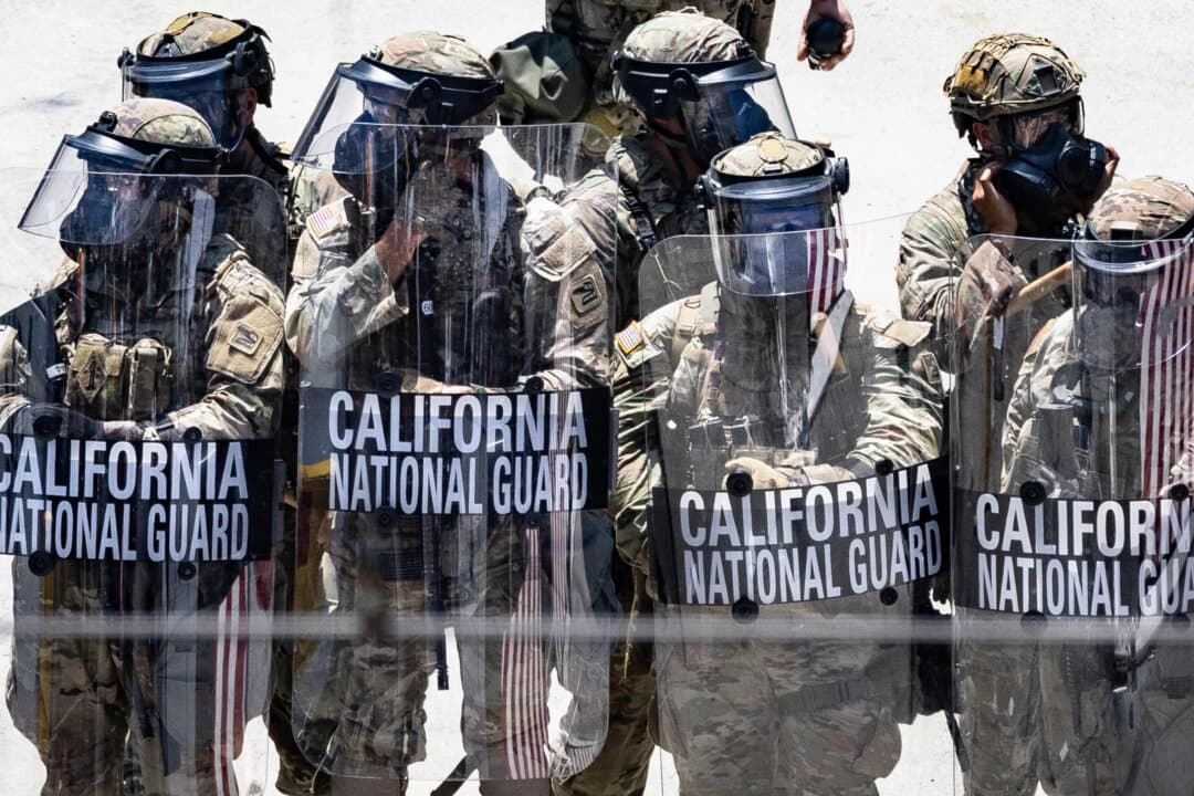 Manifestantes de inmigración se enfrentan a agentes federales y miembros de la Guardia Nacional del Ejército de California en Los Ángeles, el 8 de junio de 2025. (John Fredricks/The Epoch Times)
