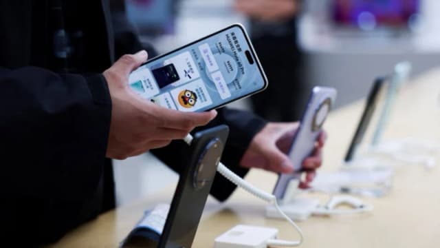 Una persona revisa un teléfono inteligente Huawei Mate 60 Pro exhibido en una tienda insignia de Huawei en Beijíng el 25 de septiembre de 2023. (Florence Lo/Reuters)