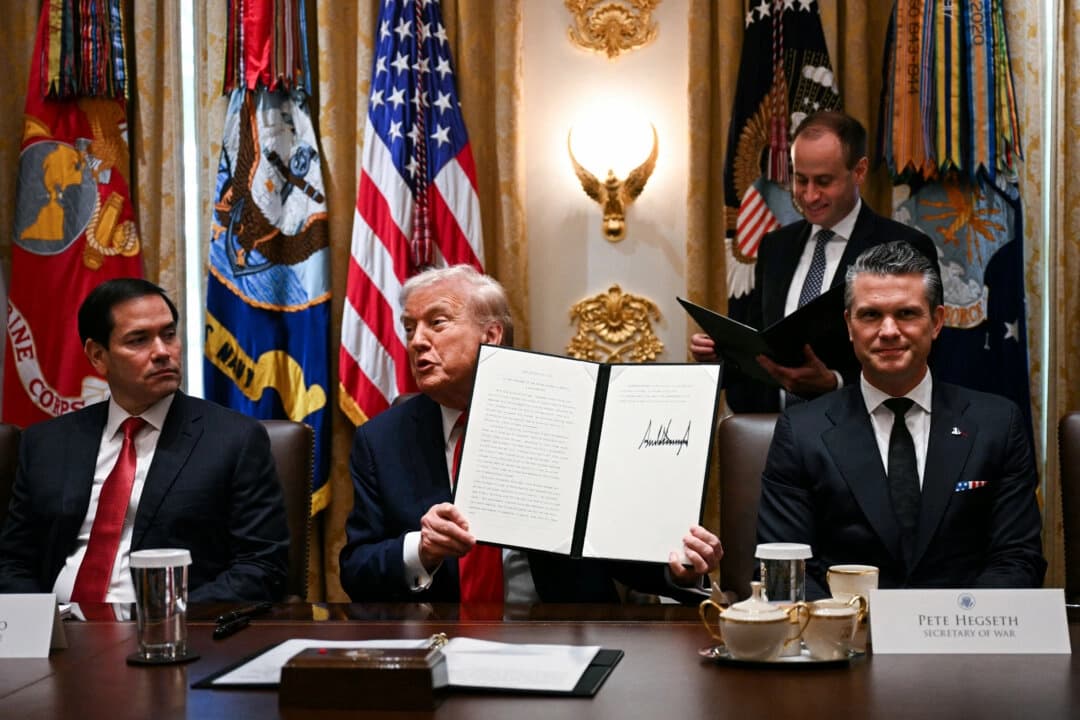 El presidente Donald Trump (C) sostiene los documentos firmados en los que se reconocen los días en honor a Leif Erikson y Cristóbal Colón mientras habla durante una reunión del Gabinete, junto al secretario de Estado Marco Rubio (I) y el secretario de Defensa Pete Hegseth (D), en la Sala del Gabinete de la Casa Blanca, el 9 de octubre de 2025. (Jim Watson/AFP a través de Getty Images)