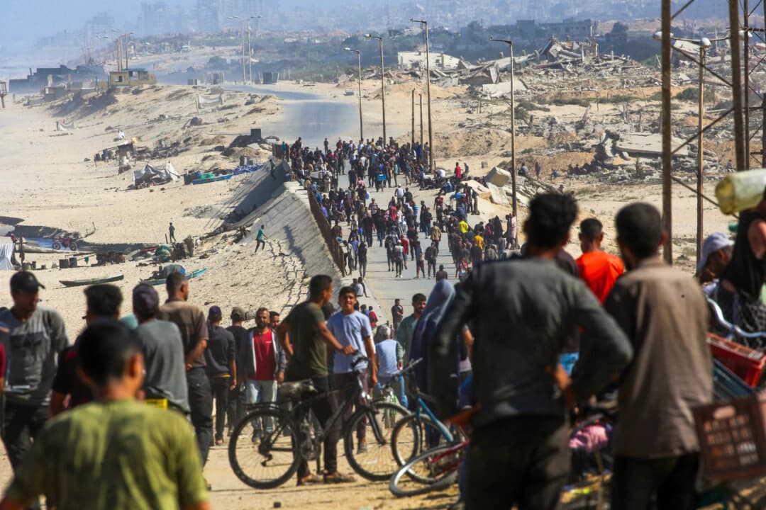 Palestinos se reúnen en una calle de Nuseirat, en el centro de la Franja de Gaza, el 10 de octubre de 2025. (Eyad Baba/AFP)