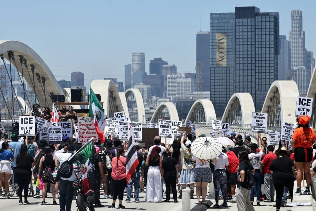 Manifestantes protestan contra las operaciones del ICE mientras bloquean el puente de la calle Sixth Street entre Boyle Heights y el centro de Los Ángeles, el 1 de julio de 2025. (Mario Tama/Getty Images)
