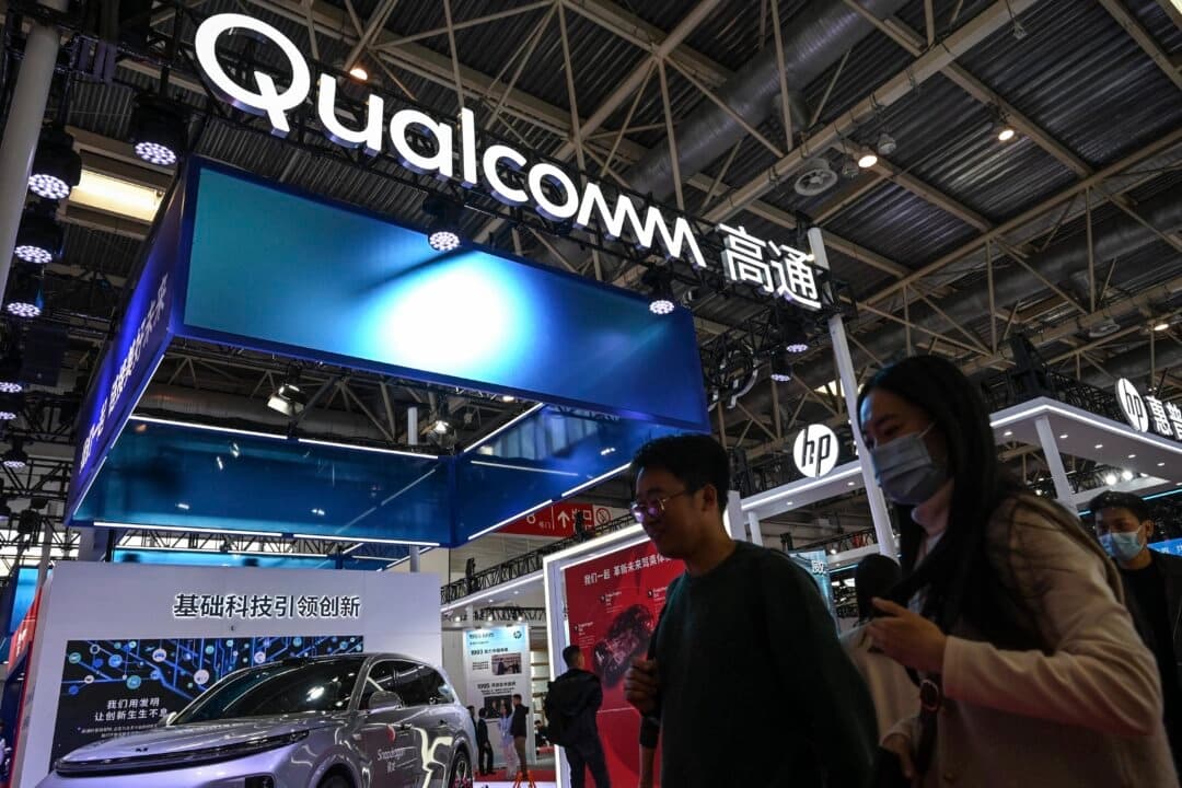 Personas pasan frente al stand de Qualcomm durante la Exposición Internacional de la Cadena de Suministro de China (CISCE) en Beijing, el 1 de diciembre de 2023. (Jade Gao/AFP a través de Getty Images).