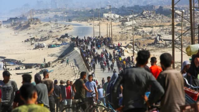 Palestinos se reúnen en una calle de Nuseirat, en el centro de la Franja de Gaza, el 10 de octubre de 2025. (Eyad Baba/AFP)