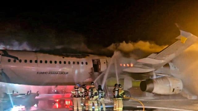 Los bomberos intentan extinguir un incendio probablemente causado por una batería de litio en un avión de Air Busan en el Aeropuerto Internacional de Gimhae, en Busan (Corea del Sur), el 28 de enero de 2025. Yonhap vía Reuters.