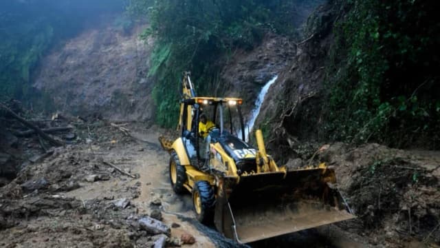 Un trabajador de la Comisión Federal de Electricidad despeja un tramo de la carretera Tulancingo-Tenango bloqueado por lodo, piedras y árboles caídos tras las fuertes lluvias en el estado de Hidalgo, México, el 11 de octubre de 2025. El número de muertos por las fuertes lluvias en México ascendió a 37 el sábado tras confirmarse nueve fallecimientos más, informó el gobierno mexicano. (ALFREDO ESTRELLA/AFP vía Getty Images)