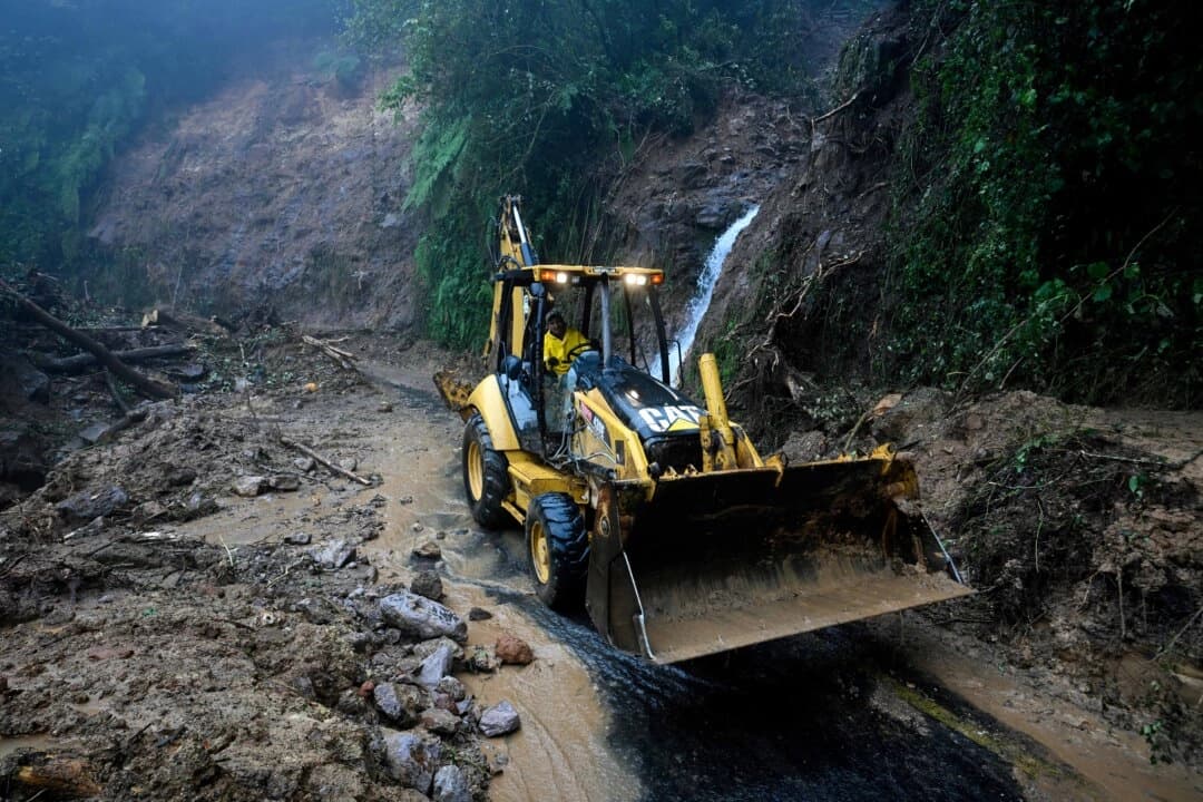 Un trabajador de la Comisión Federal de Electricidad despeja un tramo de la carretera Tulancingo-Tenango bloqueado por lodo, piedras y árboles caídos tras las fuertes lluvias en el estado de Hidalgo, México, el 11 de octubre de 2025. El número de muertos por las fuertes lluvias en México ascendió a 37 el sábado tras confirmarse nueve fallecimientos más, informó el gobierno mexicano. (ALFREDO ESTRELLA/AFP vía Getty Images)