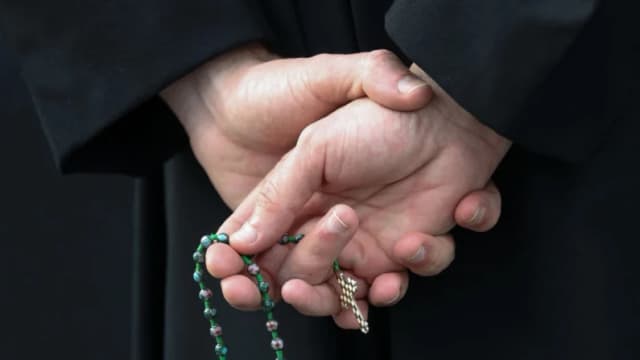 Un hombre sostiene un rosario en el estacionamiento de una iglesia en Bowie, Maryland, el 20 de marzo de 2020. (Rob Carr/Getty Images)