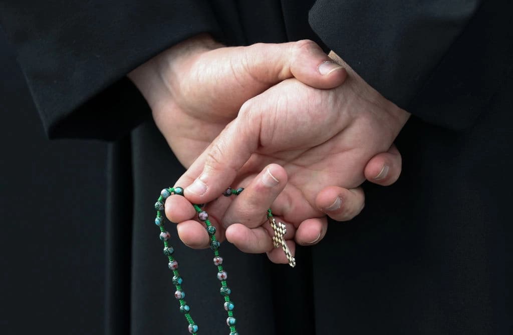 Un hombre sostiene un rosario en el estacionamiento de una iglesia en Bowie, Maryland, el 20 de marzo de 2020. (Rob Carr/Getty Images)