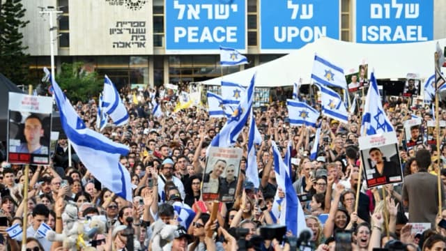 La gente se reúne para ver la retransmisión en directo de la liberación de los rehenes en la Plaza de los Rehenes de Tel Aviv, Israel, el 13 de octubre de 2025. (Alexi J. Rosenfeld/Getty Images)