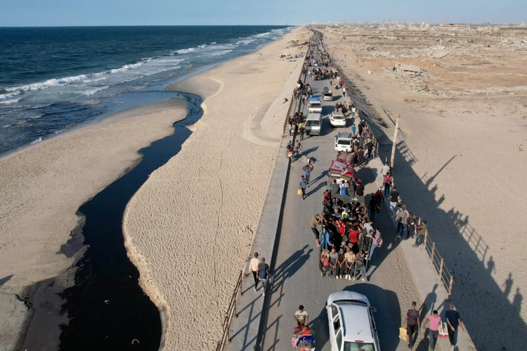 Una vista aérea muestra a palestinos que fueron desplazados a la parte sur de Gaza por orden de Israel durante la guerra, abriéndose camino por una carretera para regresar al norte después de que entrara en vigor un alto el fuego entre Israel y Hamás en Gaza, en el centro de la Franja de Gaza, el 10 de octubre de 2025. (Stringer/Reuters)
