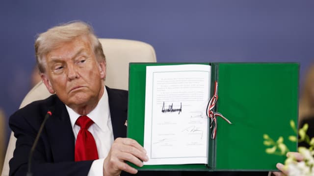 El presidente Donald Trump muestra un documento firmado durante la Cumbre de Paz de Gaza en Sharm El-Sheikh, el 13 de octubre de 2025. (Yoan Valat/POOL/AFP a través de Getty Images)