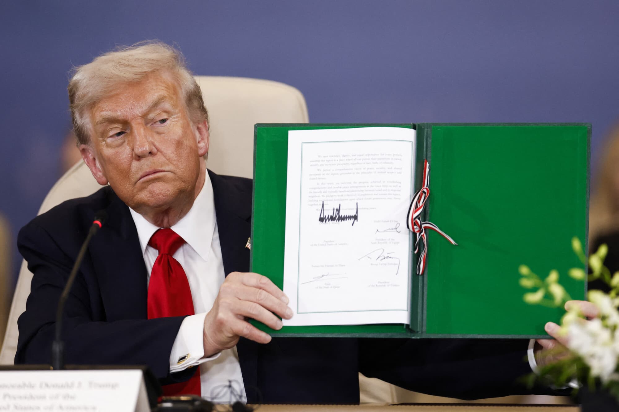El presidente Donald Trump muestra un documento firmado durante la Cumbre de Paz de Gaza en Sharm El-Sheikh, el 13 de octubre de 2025. (Yoan Valat/POOL/AFP a través de Getty Images)
